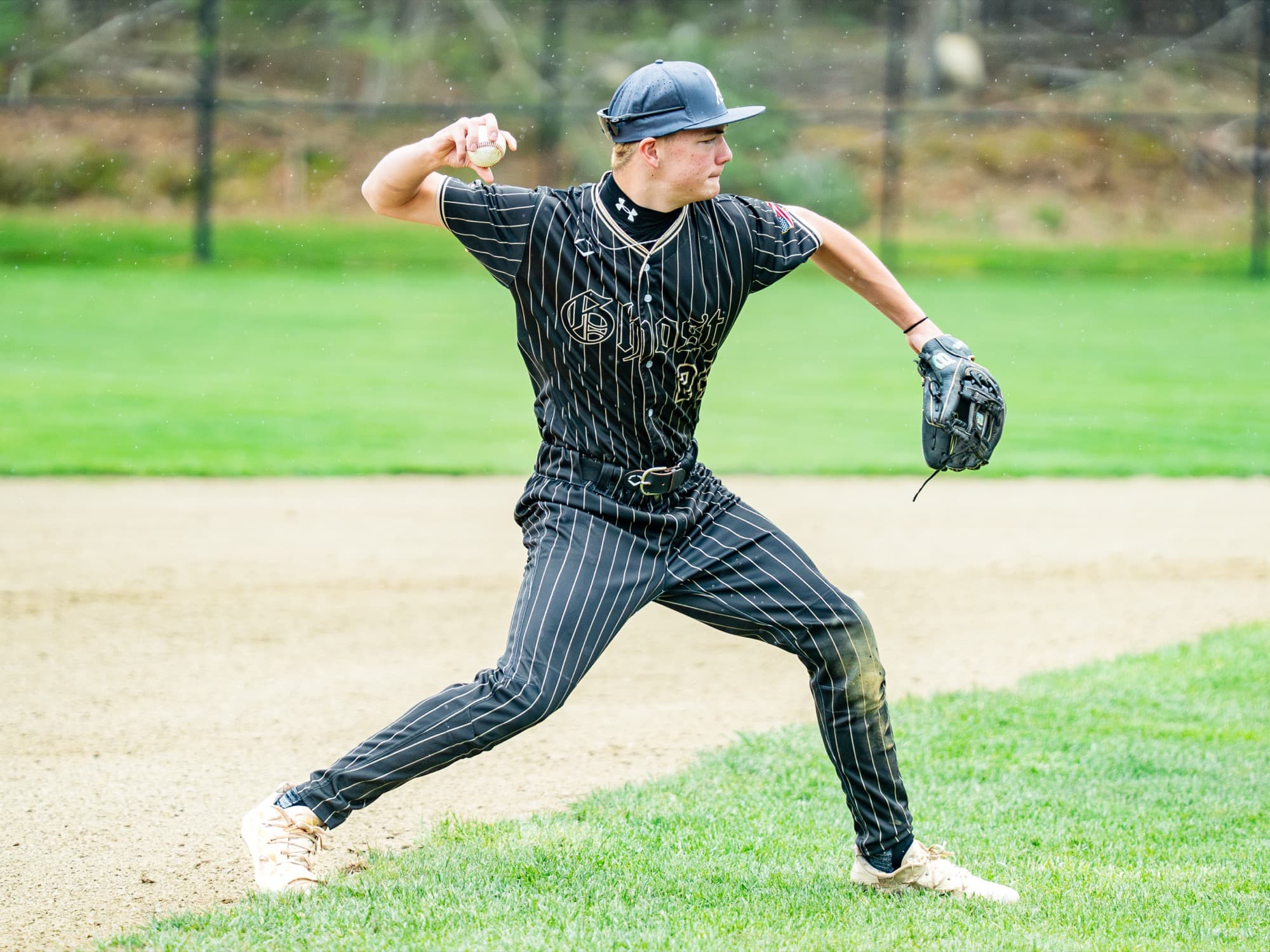 Ghost Premier player mid-throw in pinstripe uniform